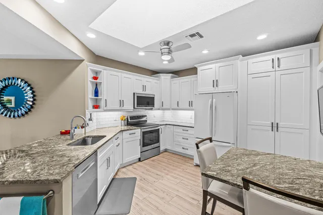 a kitchen with granite countertop a sink appliances cabinets and furniture