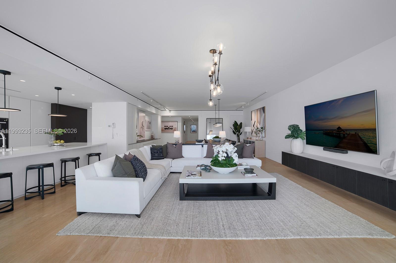 9111 Collins Avenue, Unit N717 Surfside, FL 33154 - Photo 6 of 68 a living room with furniture and a flat screen tv