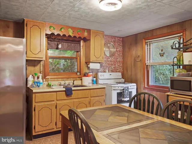 a kitchen with stainless steel appliances a stove a sink dishwasher and cabinets with wooden floor