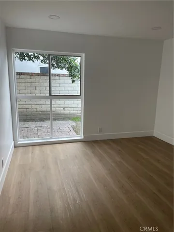 a view of a room with wooden floor and a window