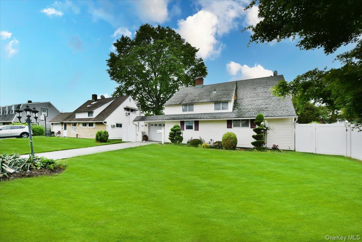 307 Blacksmith Road Levittown, NY 11756 - Photo 3 of 27 a view of a house next to a big yard and large trees
