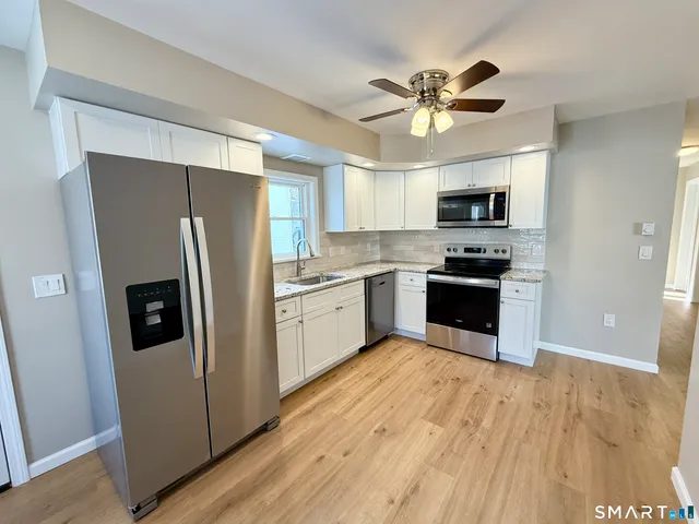 a kitchen with stainless steel appliances a refrigerator sink and stove