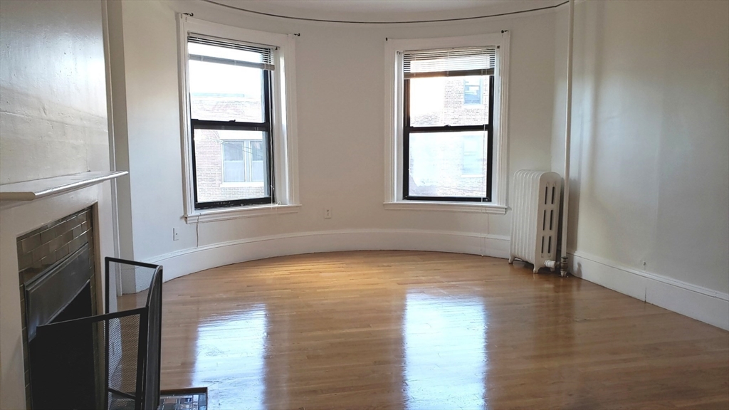 924 Beacon Street, Unit 6 Boston, MA 02215 - Photo 5 of 28 a view of an empty room with wooden floor and a window
