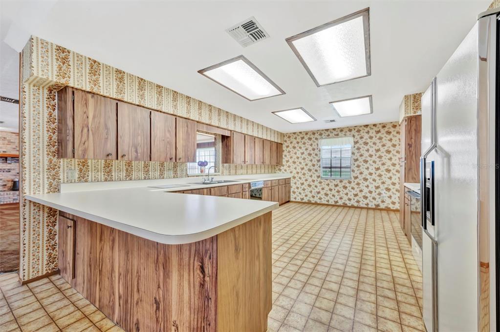 7015 Spears Road Plant City, FL 33567 - Photo 22 of 77 a kitchen with stainless steel appliances granite countertop a sink a oven and a refrigerator with wooden floor
