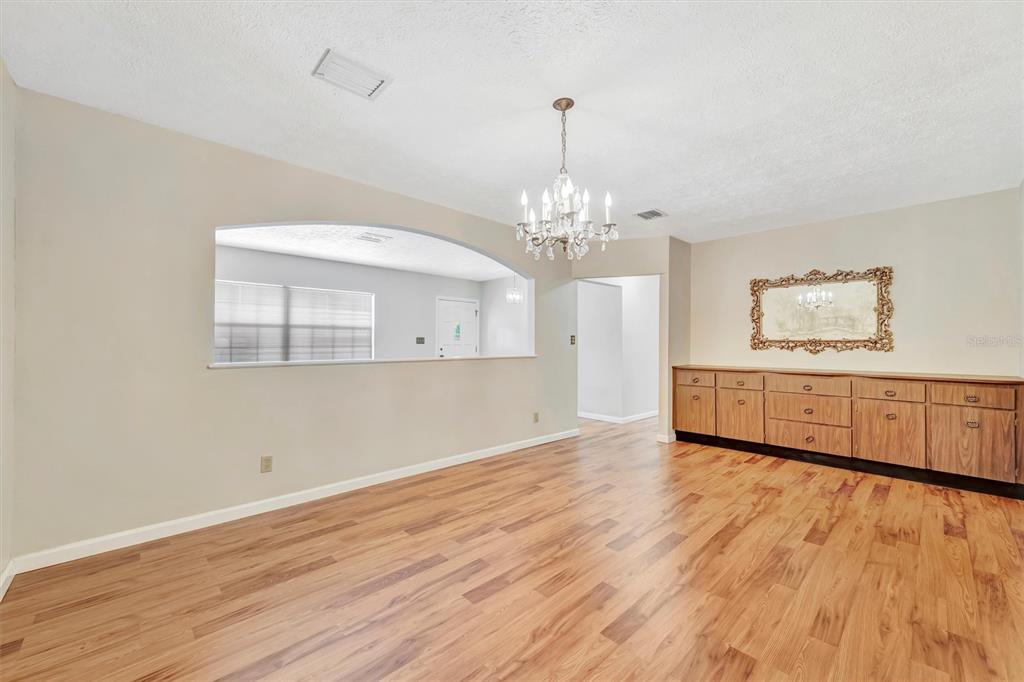 7015 Spears Road Plant City, FL 33567 - Photo 7 of 77 a view of a room with wooden floor and chandelier