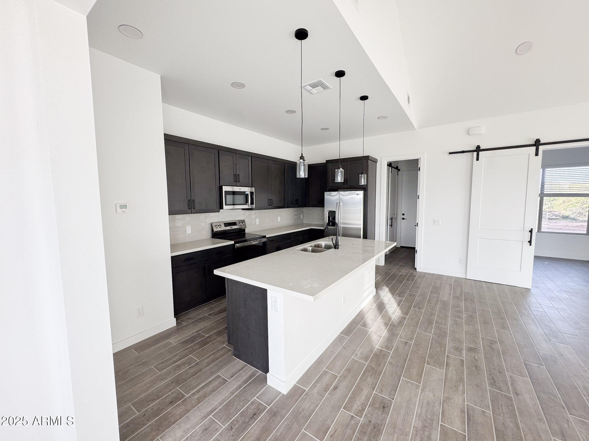 16143 East Lowden Court Scottsdale, AZ 85262 - Photo 5 of 20 a large kitchen with stainless steel appliances a large counter top a sink a refrigerator and a microwave