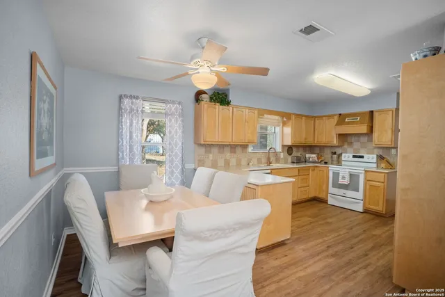 a kitchen with a table chairs stove a sink dishwasher and cabinets