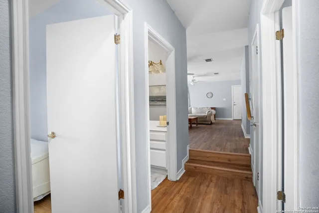 a view of a hallway with wooden floor and closet