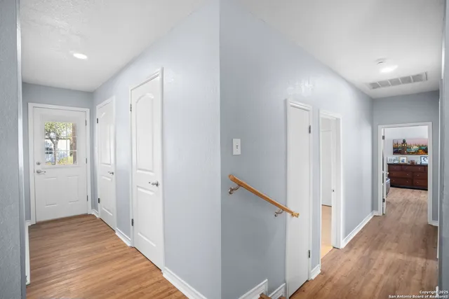 a view of a hallway with wooden floor