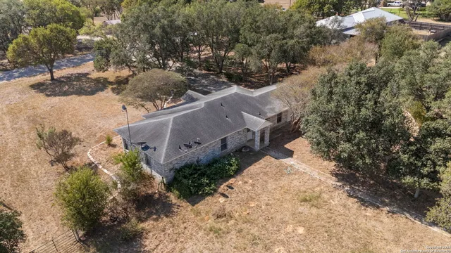 an aerial view of a house with a yard and mountain view in back