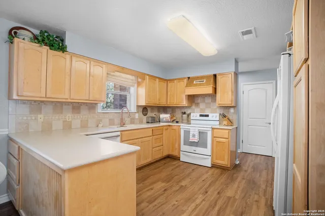 a kitchen with a white cabinets and wooden floor