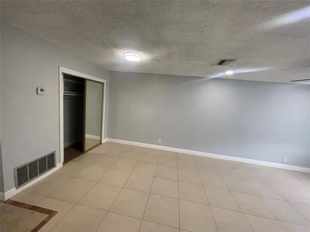 an empty room with fan and entrance