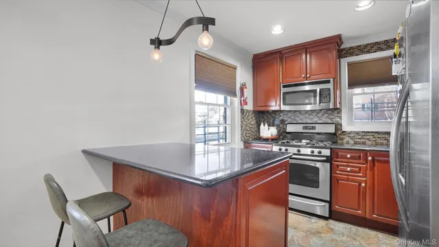 a kitchen with stainless steel appliances granite countertop a sink stove and refrigerator