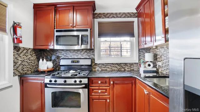 a kitchen with stainless steel appliances granite countertop a stove microwave and sink