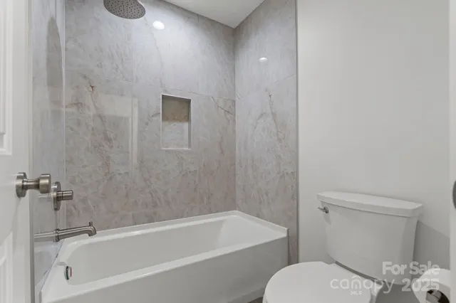 a bathroom with a granite countertop toilet a sink and bathtub