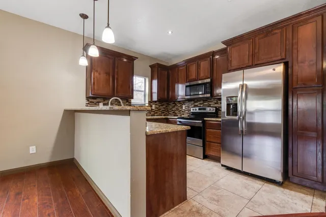 a kitchen with kitchen island a counter top space a sink and stainless steel appliances