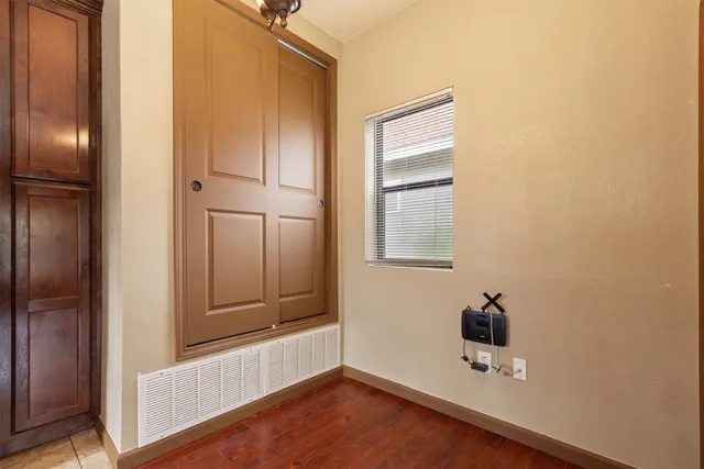 a view of an empty room with closet and wooden floor