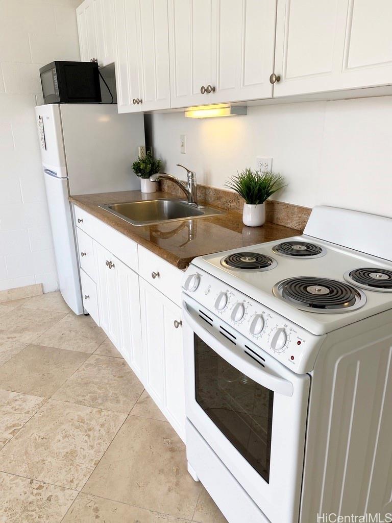 a kitchen with a stove and white cabinets