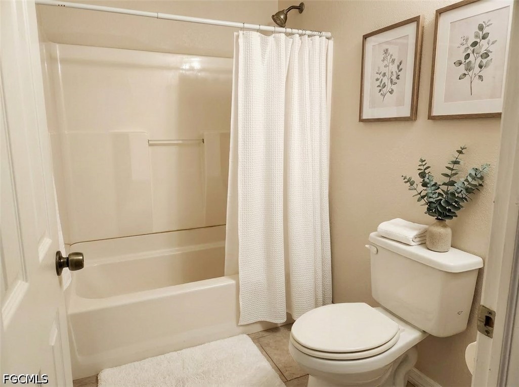 3417 19th Street Southwest Lehigh Acres, FL 33976 - Photo 12 of 14 a white toilet sitting next to a bath tub