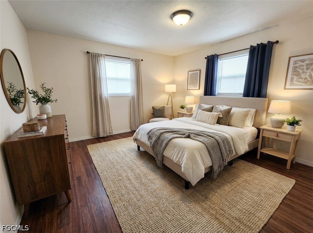 3417 19th Street Southwest Lehigh Acres, FL 33976 - Photo 9 of 14 a bedroom with a bed a mirror on dresser and a wooden floor