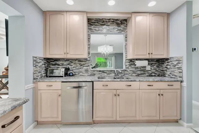 a kitchen with granite countertop a stove sink and microwave