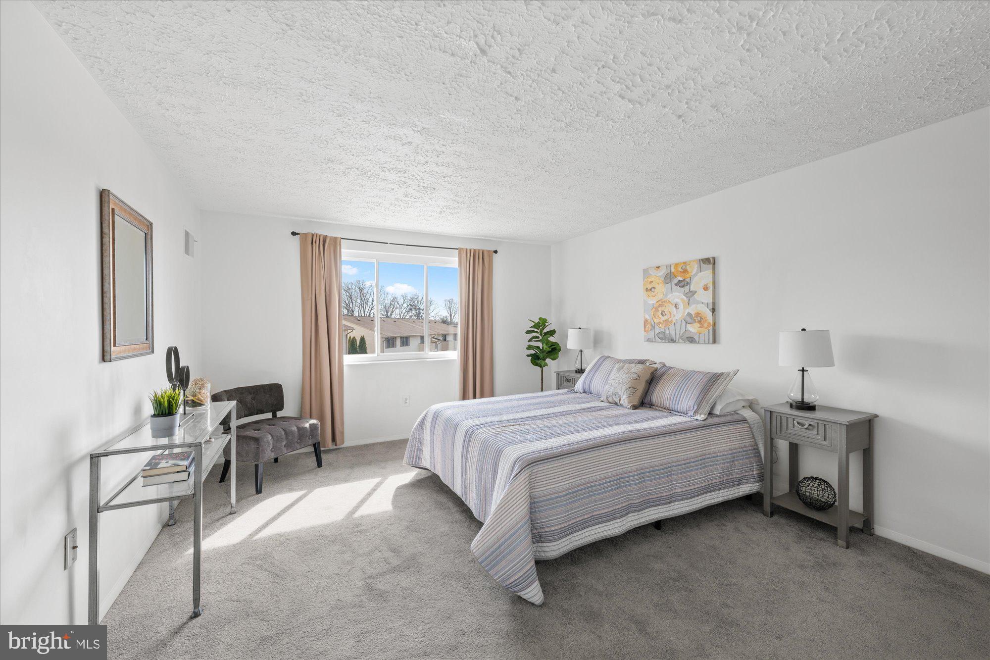 19517 Gunners Branch Road, Unit 431 Germantown, MD 20876 - Photo 13 of 23 a spacious bedroom with a bed and a table in it