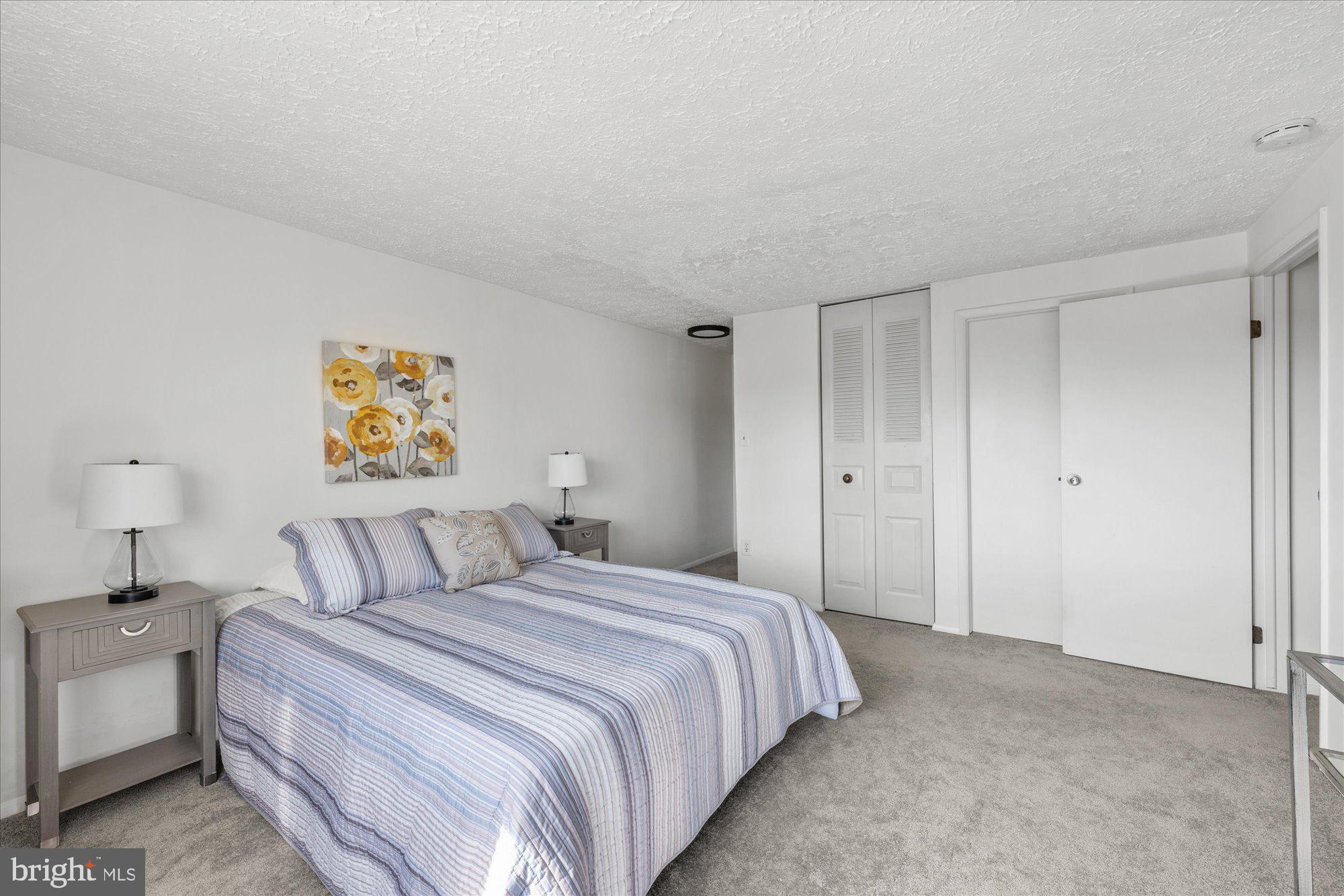 19517 Gunners Branch Road, Unit 431 Germantown, MD 20876 - Photo 14 of 23 a bedroom with a bed and a lamp on dresser