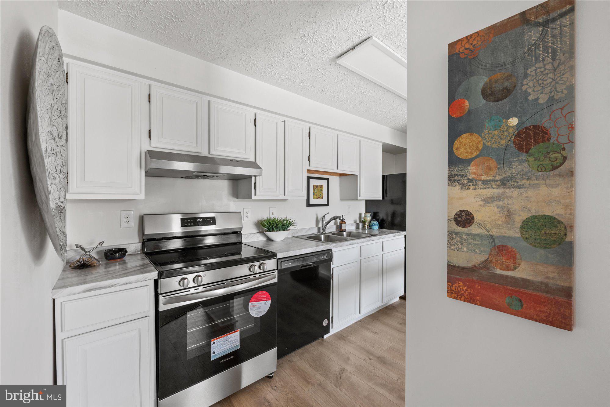 19517 Gunners Branch Road, Unit 431 Germantown, MD 20876 - Photo 5 of 23 a kitchen with stainless steel appliances a stove a sink and a refrigerator