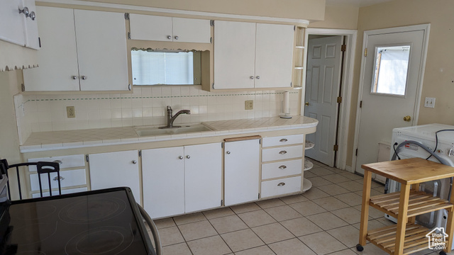 1341 East Crk Road Sandy, UT 84093 - Photo 13 of 24 Kitchen with black electric range oven, a sink, tasteful backsplash, light tile patterned floors, and white cabinetry