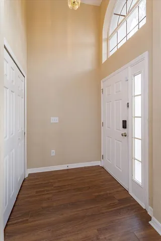 a view of an empty room with wooden floor and entryway