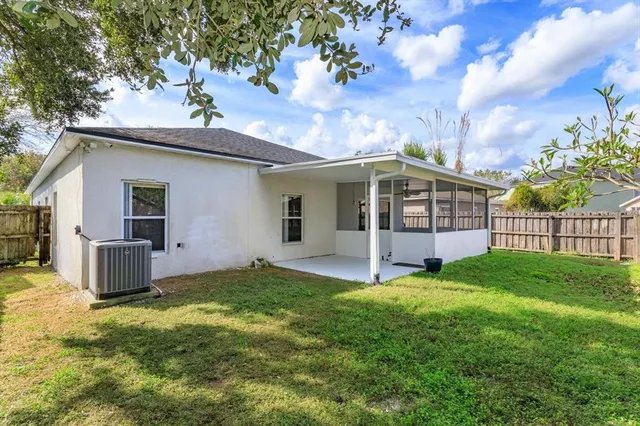 a view of a house with a yard and fence