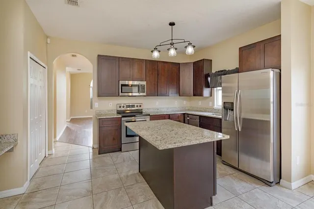 a kitchen with kitchen island granite countertop stainless steel appliances a counter top space cabinets and a center island