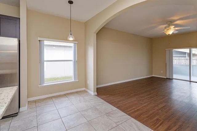 a view of an empty room with window and wooden floor