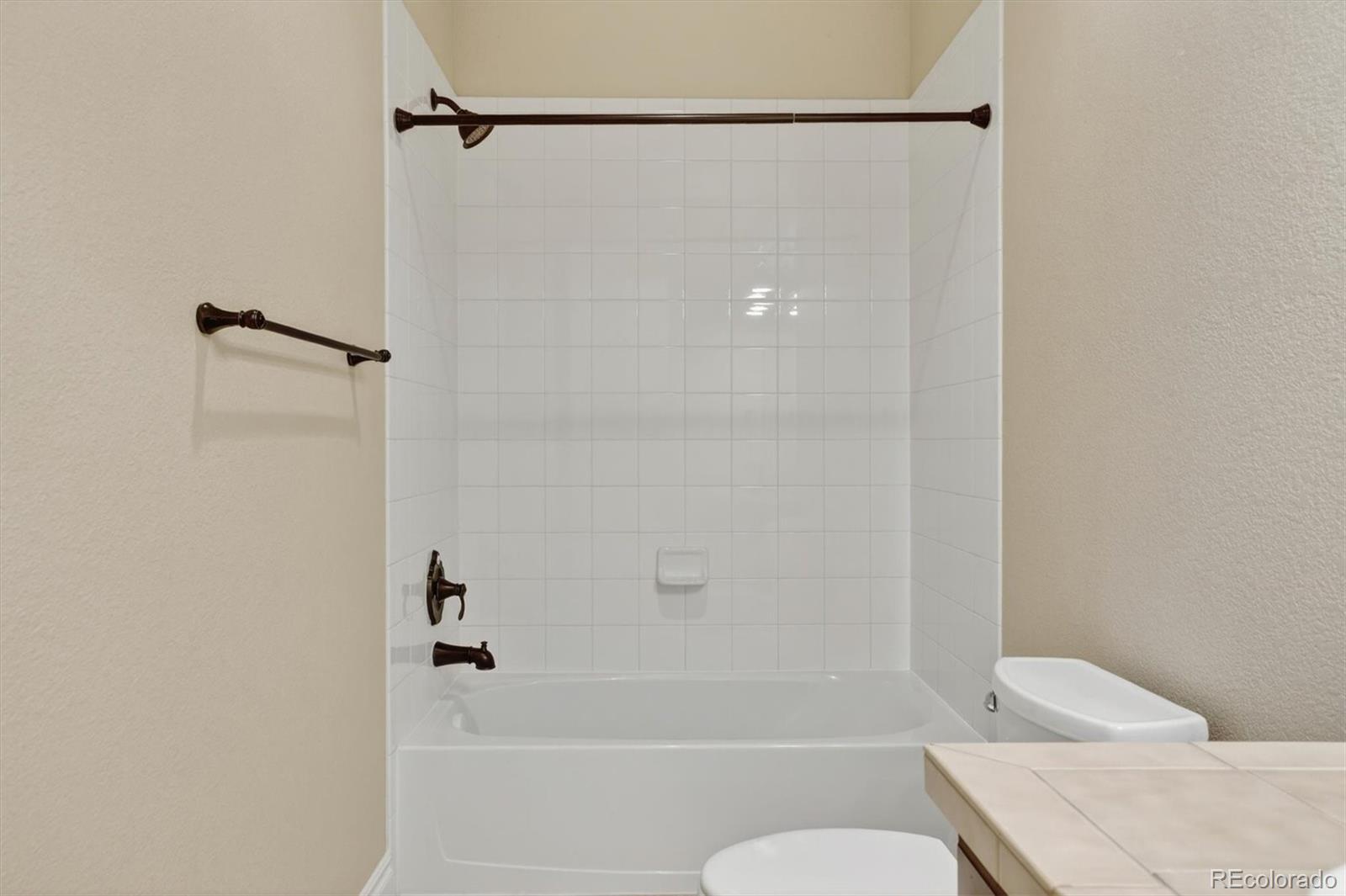 10126 RidgeGate Circle Lone Tree, CO 80124 - Photo 30 of 32 a bathroom with a bathtub and a shower