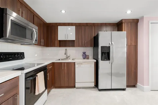a kitchen with a sink a microwave a refrigerator and cabinets