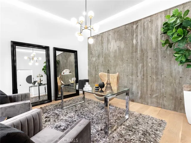 a bedroom with a bed a table and potted plant with the dresser
