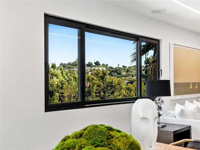 a living room with furniture flat screen tv and a large window