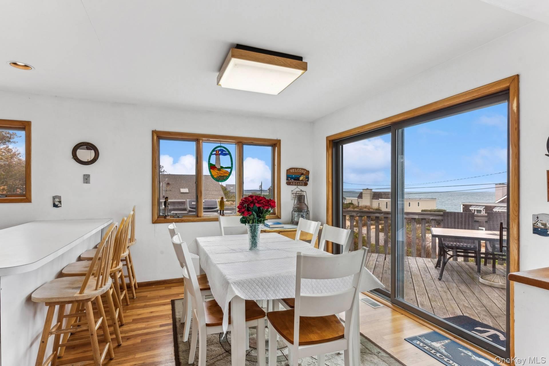 21 Captain Kidds Path Montauk, NY 11954 - Photo 12 of 30 a view of a dining room with furniture large windows and wooden floor