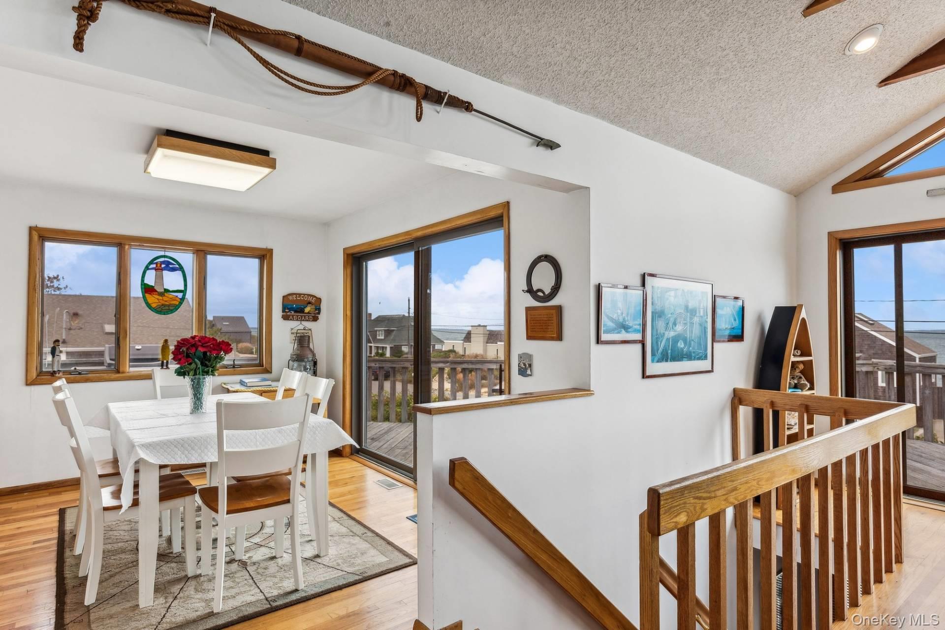 21 Captain Kidds Path Montauk, NY 11954 - Photo 17 of 30 a dining room with furniture a flat screen tv and a floor to ceiling window
