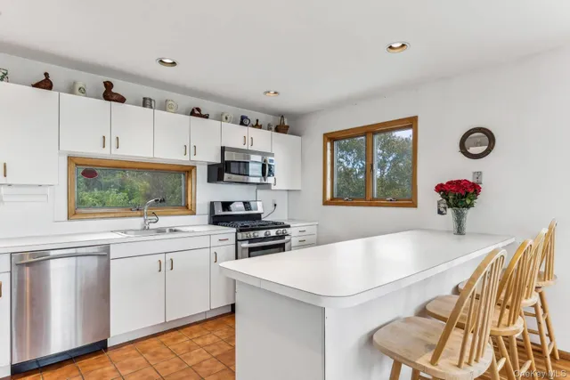 a kitchen with granite countertop a sink cabinets and stainless steel appliances