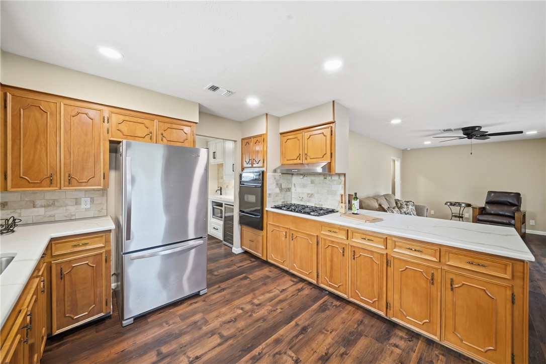 4608 Union Road North Zulch, TX 77872 - Photo 34 of 35 a kitchen with granite countertop stainless steel appliances a refrigerator counter space and wooden floor