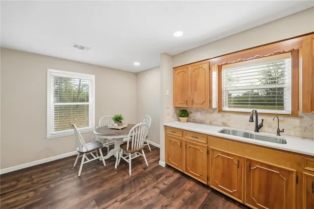 a dining room with wooden floor and stainless steel appliances