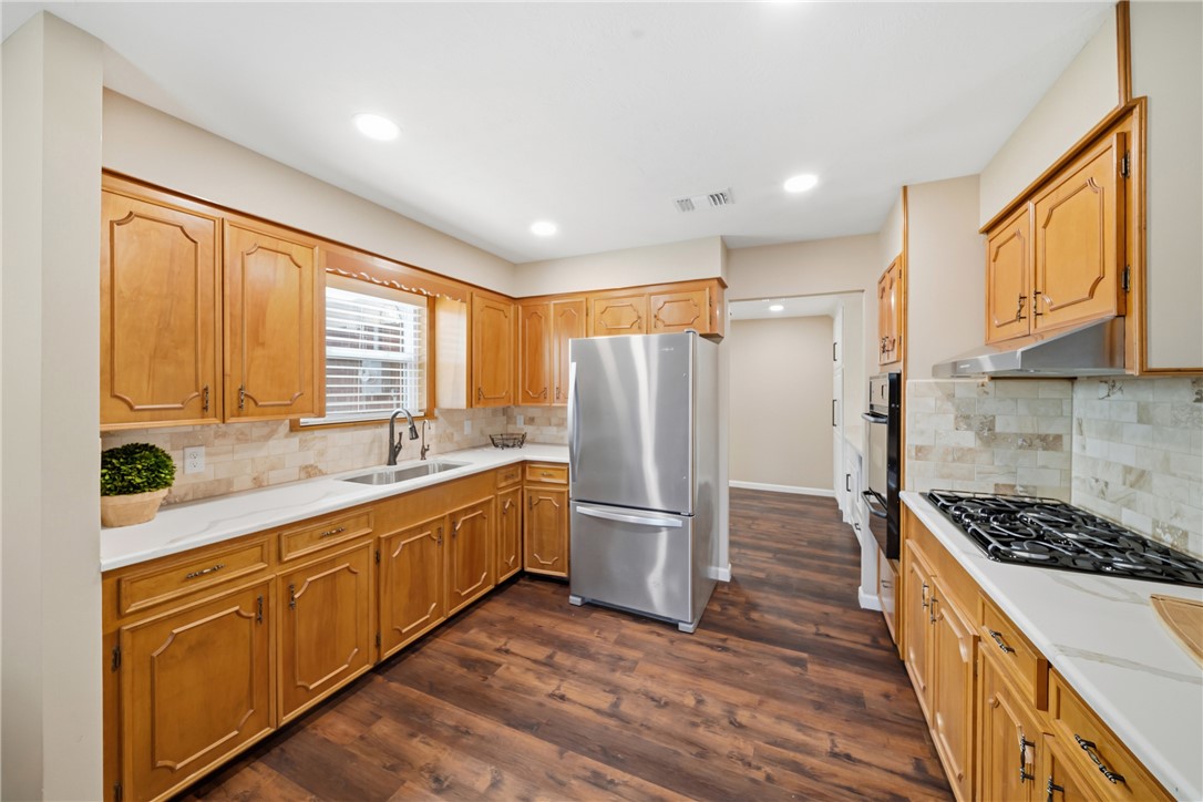 4608 Union Road North Zulch, TX 77872 - Photo 14 of 35 a kitchen with stainless steel appliances granite countertop a refrigerator a sink dishwasher and wooden cabinets with wooden floor