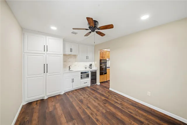 a kitchen with granite countertop a sink cabinets and stainless steel appliances