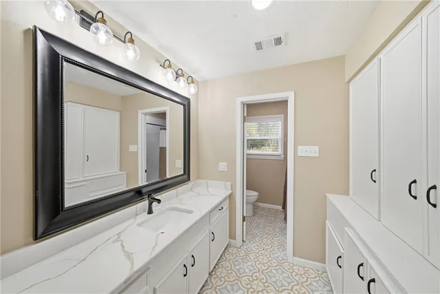 a bathroom with a double vanity sink mirror and bathtub