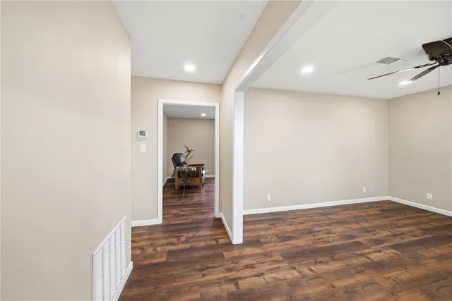 a view of an empty room with a window and a kitchen