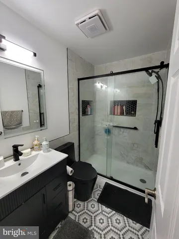a bathroom with a sink shower and a mirror