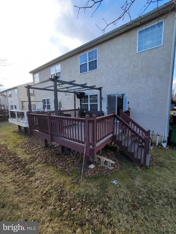 a view of a house with wooden deck and a small yard