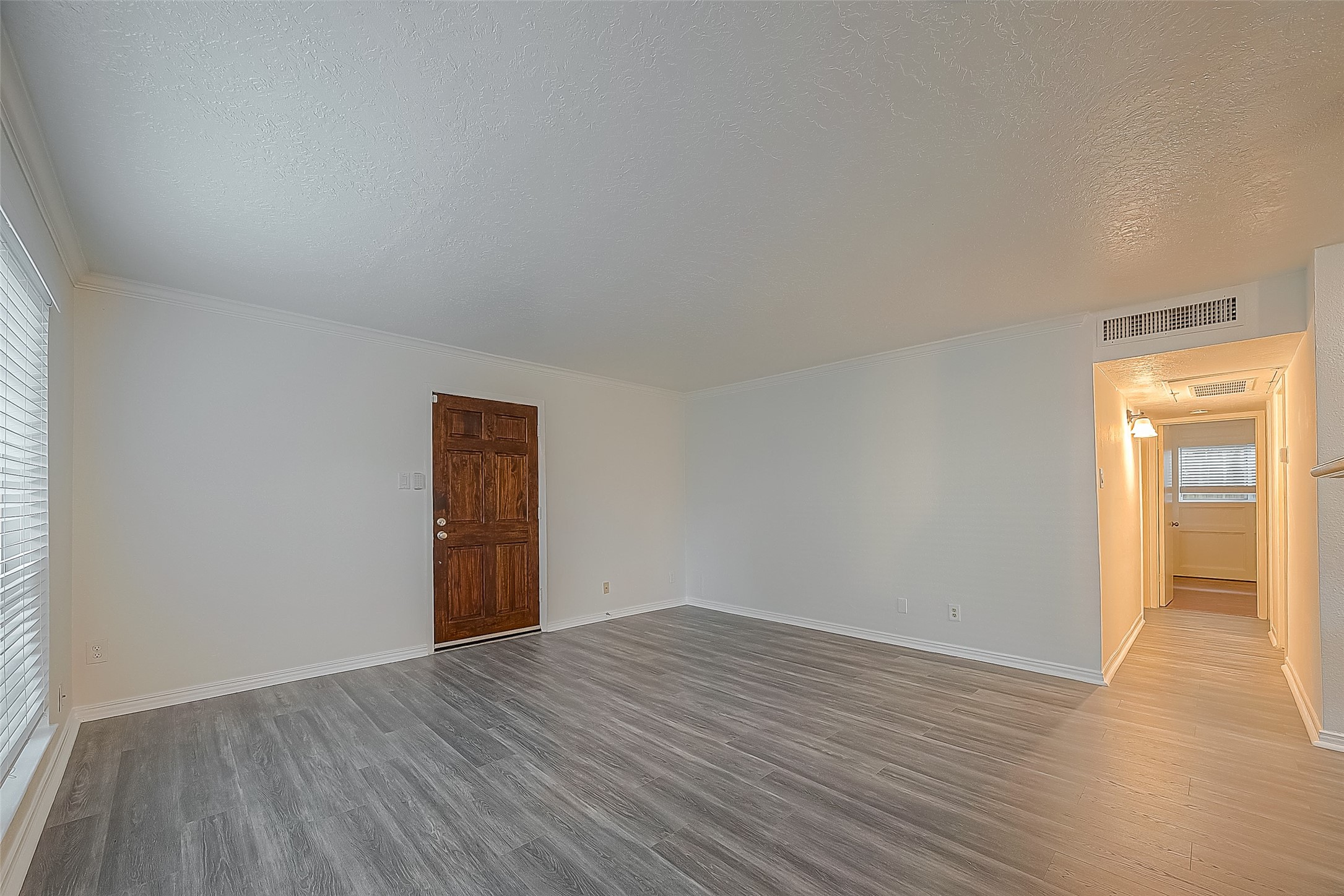 3224 Timmons Lane, Unit 147 Houston, TX 77027 - Photo 12 of 32 an empty room with wooden floor and windows