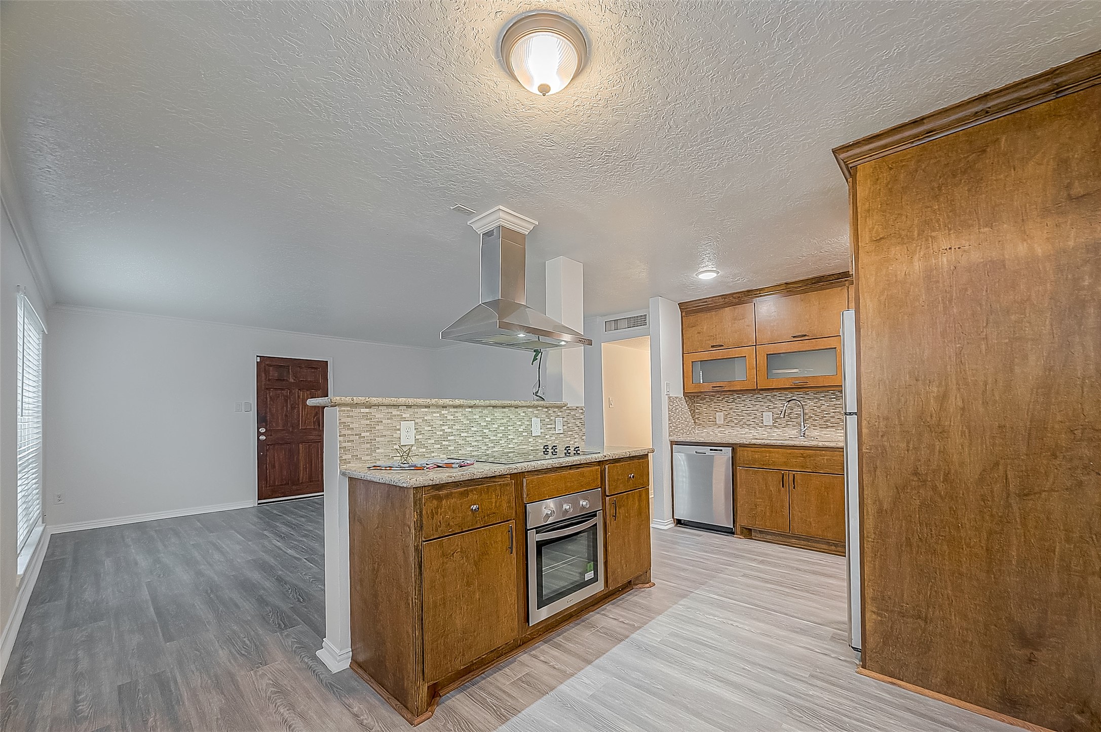 3224 Timmons Lane, Unit 147 Houston, TX 77027 - Photo 14 of 32 a kitchen with stainless steel appliances granite countertop a stove and a wooden floors